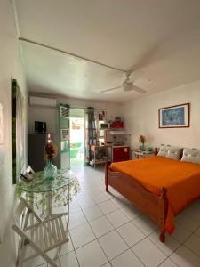 1 dormitorio con cama de color naranja y mesa en Studio confortable à Fort-de-France de 25 m² avec balcon privé, en Fort-de-France