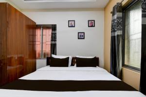 a bedroom with a bed and a window at Hotel O SS INN in Bhubaneshwar