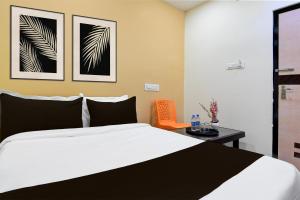 a bedroom with a bed and a table and two pictures at Hotel O SS INN in Bhubaneshwar +23 photos