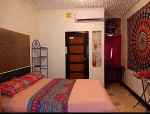 ein Schlafzimmer mit einem Bett und einer Leiter neben einer Tür in der Unterkunft Maxroomz in San Ignacio