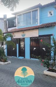 a blue house with a sign in front of it at Suites Água Viva in Búzios