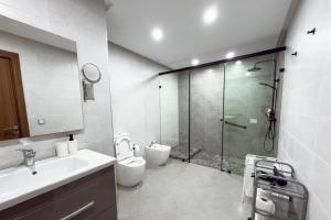 a bathroom with a shower and a toilet and a sink at Luxury Apartment with Private Patio & City Charm in Al Hoceïma