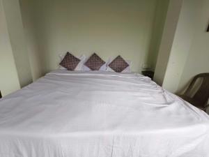 a large white bed with four pillows on it at Hotel O Sun View in Gangtok