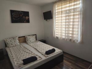 a bedroom with a bed with two pillows on it at Къща за гости Алтея in Sarovtsi +35 photos