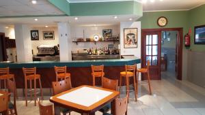 a bar in a restaurant with a table and chairs at Hotel Alameda in Villaviciosa