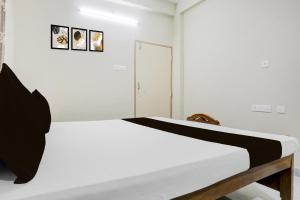 カタックにあるHotel O Kunjaban residencyの部屋にベッドが置かれた白い寝室