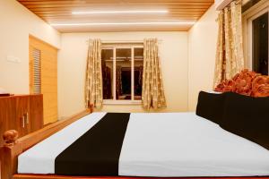 カタックにあるHotel O Kunjaban residencyの大きなベッドと窓のある寝室 +36枚の写真
