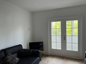 a living room with a couch and a sliding door at Apartman Boža 2 in Kuršumlija