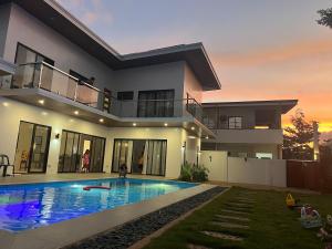 a house with a swimming pool in front of it at Villa Bella in Puerto Princesa City
