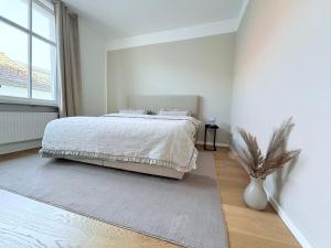 a white bedroom with a bed and a window at designAparts - II - by MorenoPisano in Bayreuth