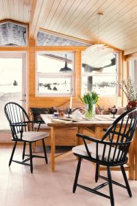 a dining room with two chairs and a table at Architect Drawn Holiday Home Near Rondane Park in Høvringen +29 photos
