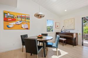 a dining room with a table and a piano at Mesa Breeze by Paradise Retreats in Santa Barbara +24 photos