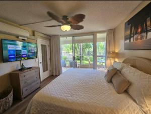 ein Schlafzimmer mit einem Bett und einem Deckenventilator in der Unterkunft Tropical Family Resort Near Beach-Full Kitchen, AC & WIFI in Wailea + 13 Fotos
