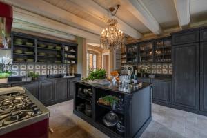 a kitchen with black cabinets and a chandelier at Maison Benedictine - Adults Only in Caprino Veronese