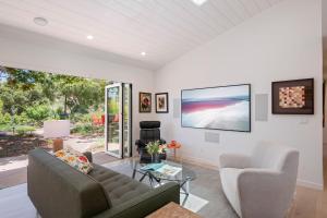 a living room with a couch and chairs and a tv at Mesa Breeze by Paradise Retreats in Santa Barbara