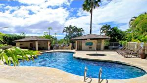 einen Pool in einem Resort mit Stühlen und einer Palme in der Unterkunft Tropical Family Resort Near Beach-Full Kitchen, AC & WIFI in Wailea