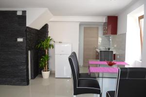 a kitchen with a dining table and black and white at Apartment Igor in Baška