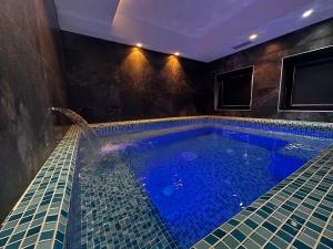 a large swimming pool with blue tiles in a room at LAKEVIEW Hotel & Apartments in Mavrovo