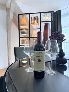 a bottle of wine sitting on a table with two wine glasses at designAparts - I - Penthouse mit Dachterrasse in Bayreuth