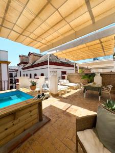 une terrasse avec une piscine et un grand parasol dans l'établissement ISG Apartments Precioso ático con terraza privada en el centro- FREE PARKING, à Séville