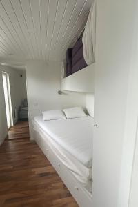 a white bed in a room with a ceiling at Strandstugan in Halmstad