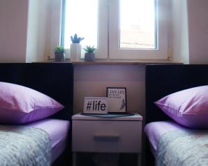 1 dormitorio con 2 camas y almohadas rosas y blancas en Hoc Loco Split en Split