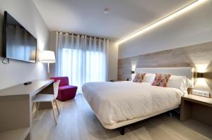 a hotel room with a bed and a desk and a chair at Hotel Lemik in Alsasua