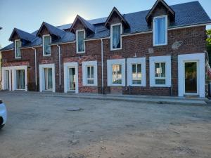 a large brick building with a lot of windows at Hameau des Essarts in Grand-Couronne