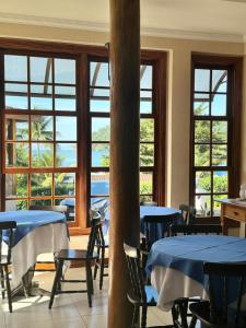 パラチにあるPousada dos Navegantesのテーブルと椅子と窓のあるダイニングルーム