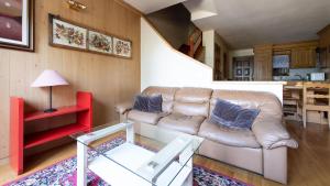 a living room with a leather couch and a table at Monte Solena 45C in Bormio