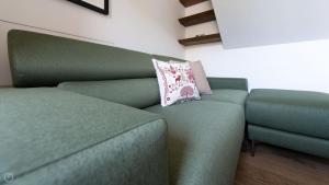 a green couch with a pillow on top of it at Morcelli 4 - Bajona in Bormio
