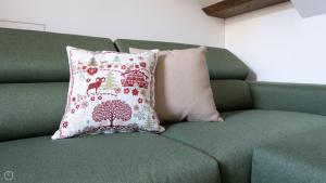 a green couch with a pillow on it at Morcelli 4 - Bajona in Bormio +110 photos