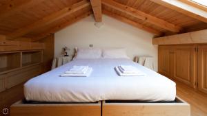 a bed with two towels on top of it in a room at Monte Solena 45C in Bormio