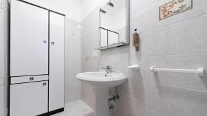 a white bathroom with a sink and a mirror at Monte Solena 45C in Bormio +54 photos