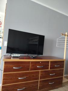 a wooden dresser with a television on top of it at Atakama loft in Caldera