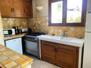 una cocina con fregadero y estufa en Résidence Lavoir1 - Maison de caractère en plein centre du village de Villard de Lans MAE-3424, en Villard-de-Lans