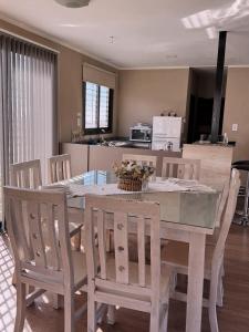 a dining room table with chairs and a kitchen at El Contenedor in Tunuyán