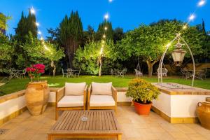 普罗奇达B&B PROCHYTEA的庭院设有两把椅子和一张桌子,还有一个喷泉