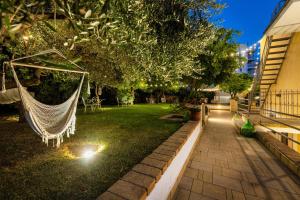 a hammock in a garden at night with lights at B&B PROCHYTEA in Procida +102 photos
