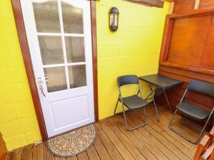 a porch with a door and two chairs and a table at Lancaster in Lincoln
