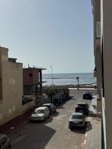 a street with cars parked next to the beach at Appartement de rêve à El Jadida, à proximité de la mer in El Jadida