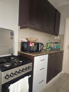 een keuken met een fornuis en een magnetron bij One Bedroom Apartment by Birnes Haven in Ongata Rongai 