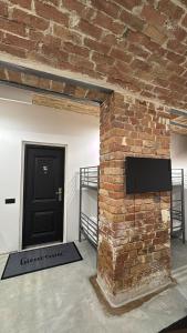 a brick wall with a tv and a door at Wagner's Refuge 1 in Riga +8 photos