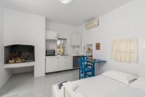 a white room with a bed and a kitchen at Paraspori in Adamantas