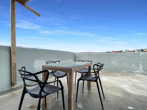 a table and four chairs on a balcony with a view at Econômico Plaza Shopping 1 Quarto Central in Carapicuíba
