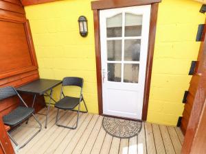 a porch with two chairs and a table and a door at Dakota in Lincoln