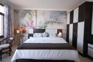 a bedroom with a large bed with a large painting on the wall at Wandernest Homes Casa Da Flora in Mashobra