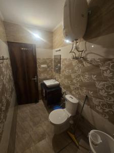 a bathroom with a toilet and a sink at Wandernest Homes Casa Da Flora in Mashobra