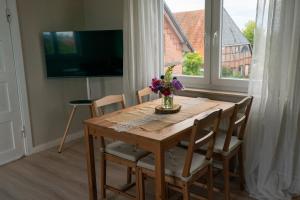 a dining room table with a vase of flowers on it at Ferienwohnung Am Hafen in Bleckede