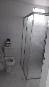 a bathroom with a toilet and a glass shower stall at Casa COP 30 in Belém